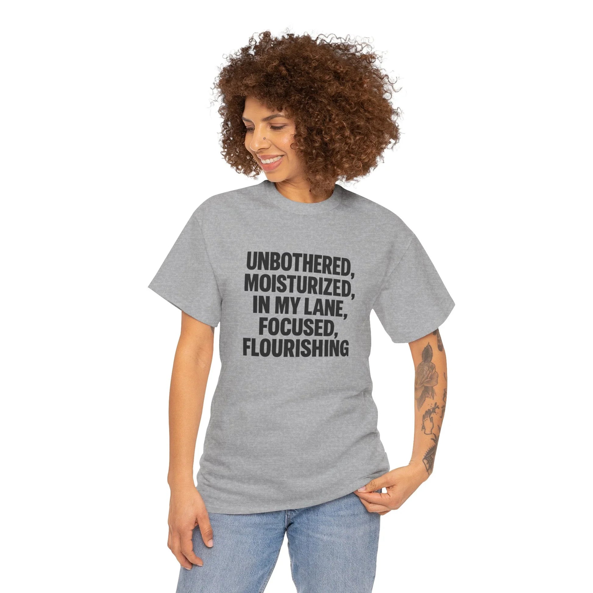 Woman in grey graphic tee with 'Unbothered, Moisturized, In My Lane' text, casual fashion