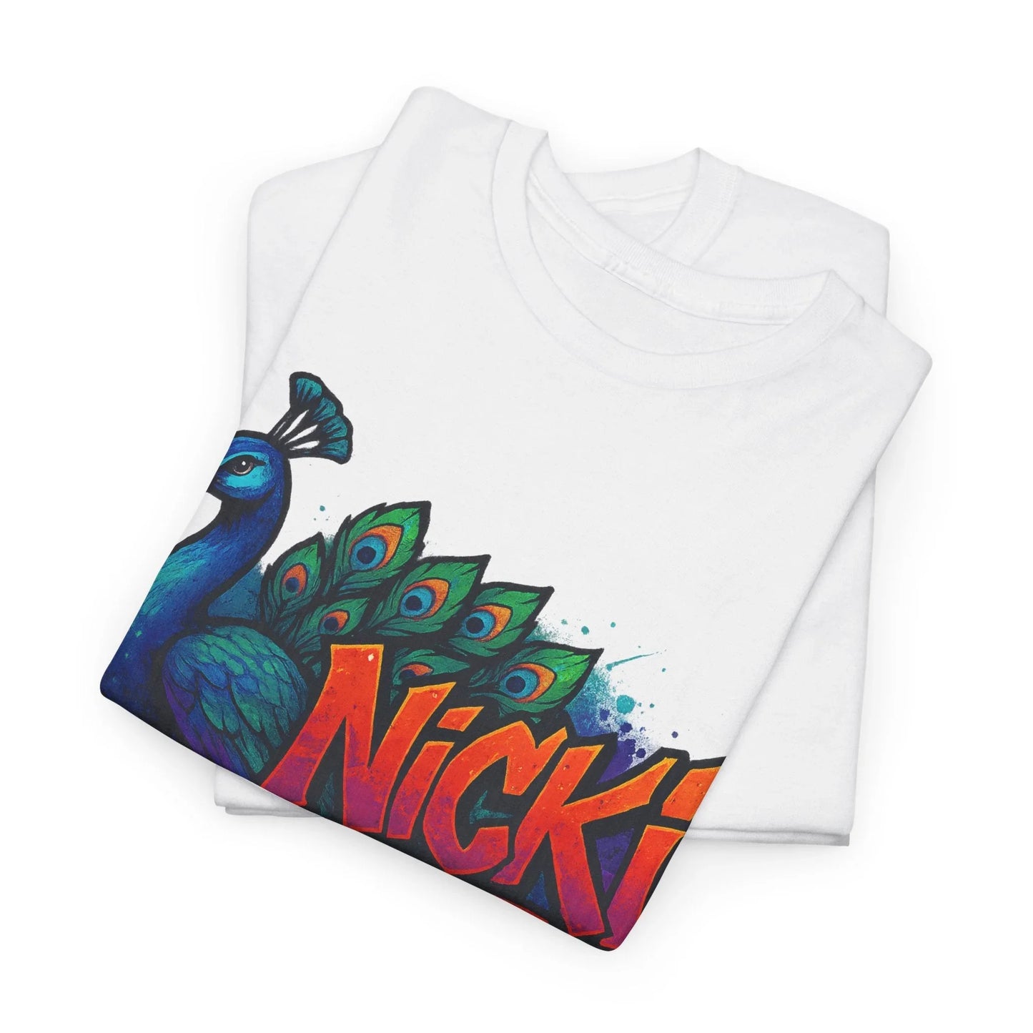 Folded white t-shirt with colorful peacock graphic and bold 'Nicki' text