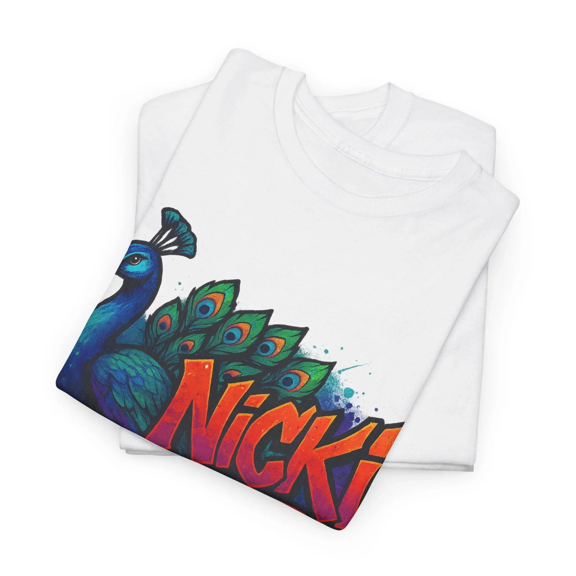 Folded white t-shirt with colorful peacock graphic and bold 'Nicki' text